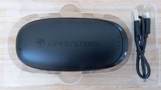 Lifesystems Rechargeable Hand Warmer XT on desk in plastic packaging