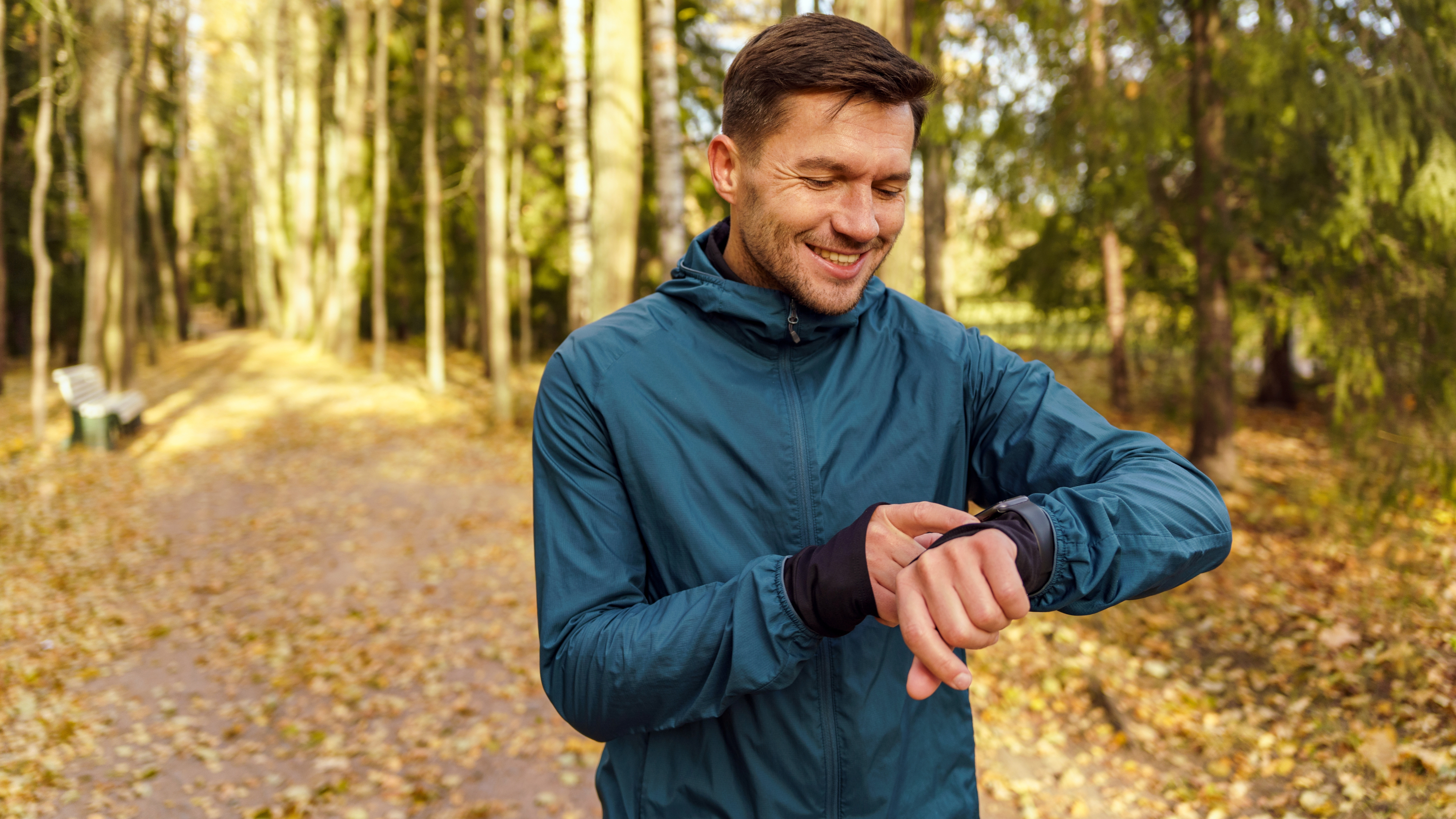 a man running in a forest checking his watch