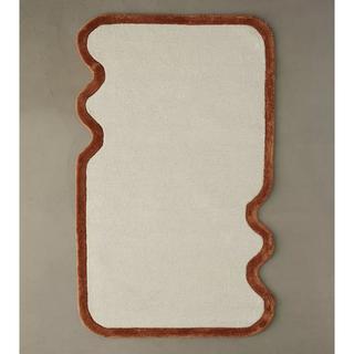 cream rug with a contrast brown border with wavy detail