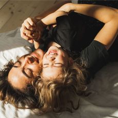 Happy mother and daughter having fun and playing together on the bed at home. Love of a mother and baby. Family playing in bedroom.