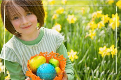 Portrait smiling girl with Easter egg candy in daffodil field - stock photo