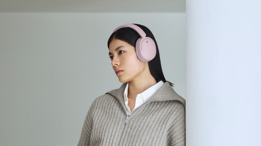 Sony WH-CH730N wireless headphones in pink being worn by a woman