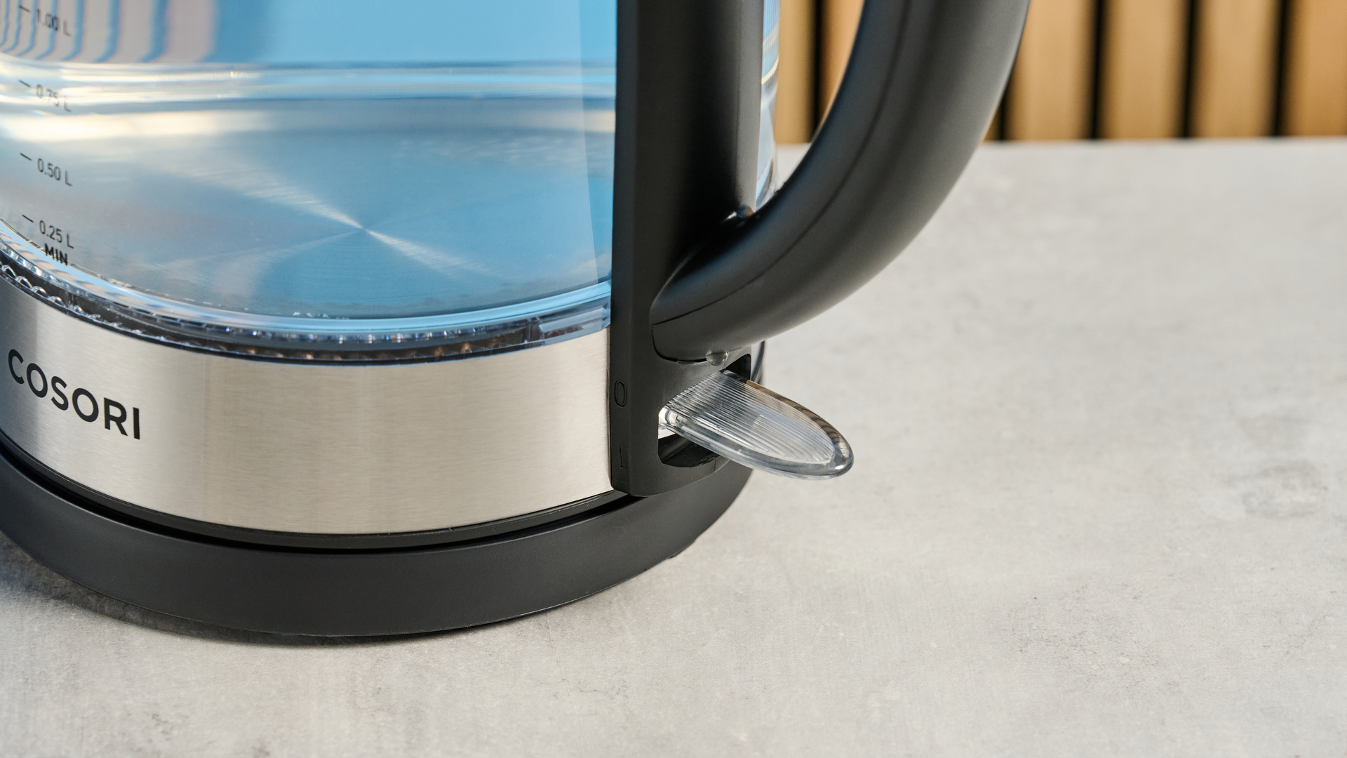 Cosori Electric Glass Kettle photographed in front of a blue background.