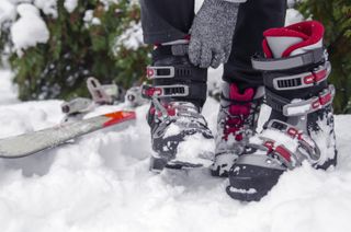 Close-up of a person strapping up red and black ski boots 