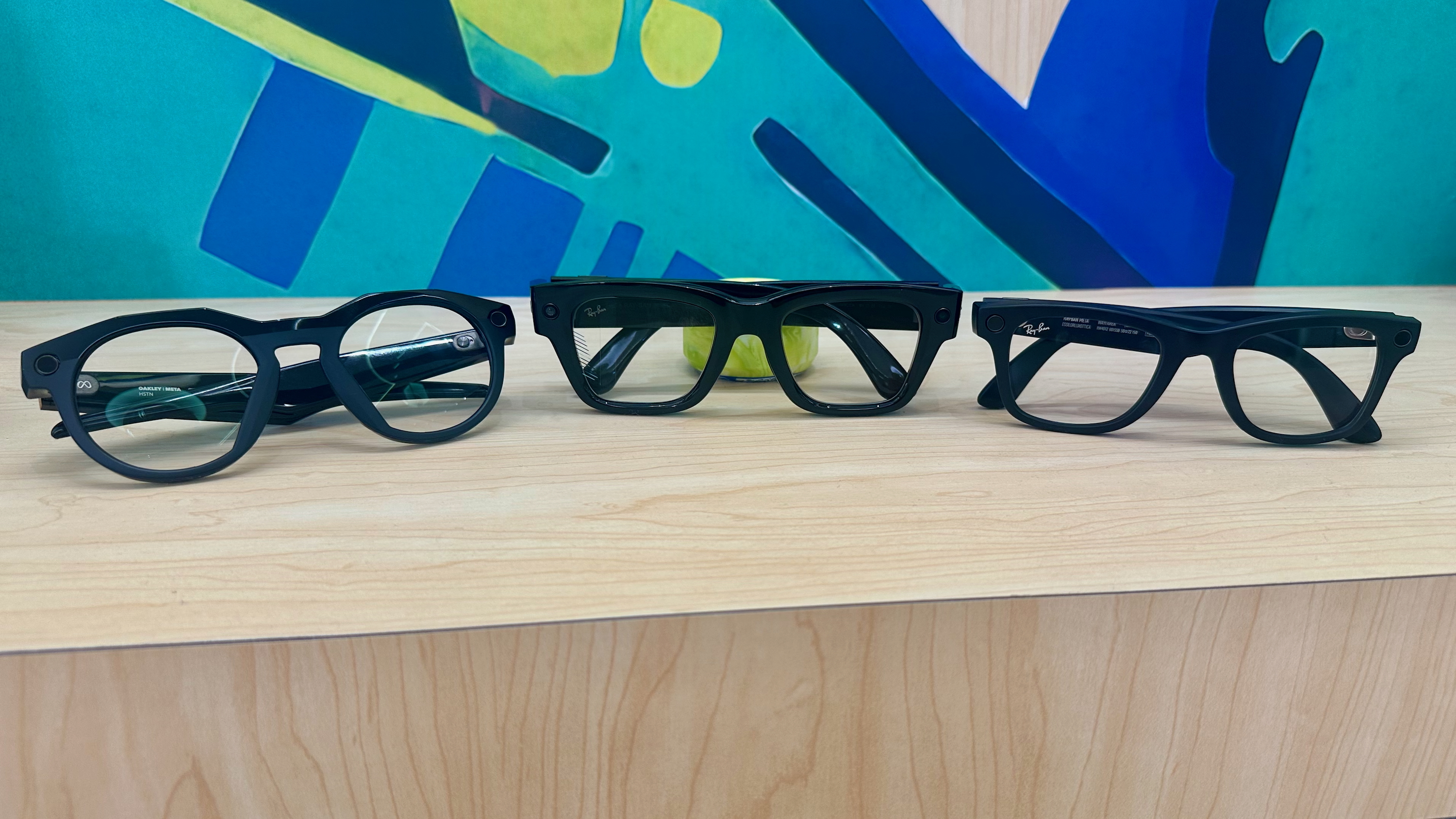 A photo of Oakley Meta HSTN (left), Meta Ray-Ban Display (center), and Ray-Ban Meta Gen 2 (right) smart glasses sitting folded next to each other from a front view.
