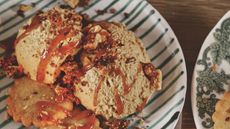 Butterscotch mousse with sauce and biscuits on a green and white striped plate