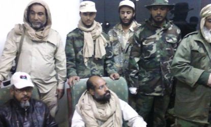 A mobile phone picture taken by one of his guards shows Gadhafi's son, Saif al-Islam, sitting with his captors in Libya's Obari airport.