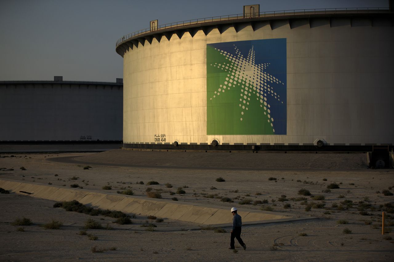 An employee walks past crude oil storage tanks at the Juaymah Tank Farm in Saudi Aramco&amp;#039;s Ras Tanura oil refinery and oil terminal in Ras Tanura, Saudi Arabia, on Monday, Oct. 1, 2018. Saudi 