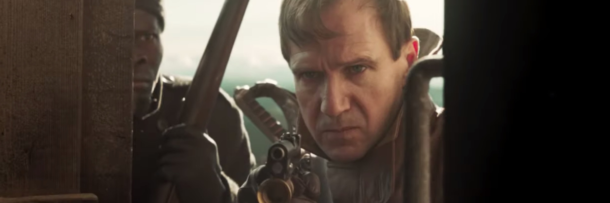 The King's Man Ralph Fiennes enters a room with a gun drawn