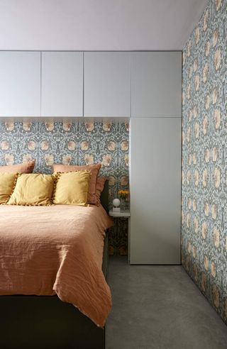A bedroom with wallpaper behind the bed and on the walls