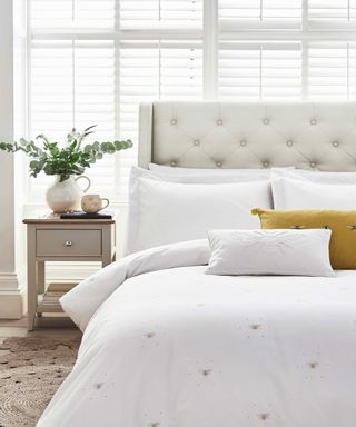 bedroom with white bedding and white venetian blinds