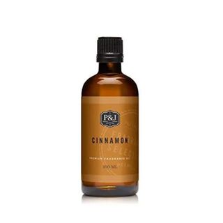 A brown glass bottle of P&j Trading - Cinnamon Scented Oil 100ml with black lid and orange label