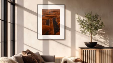 The Pocketbook InkPoster Tela on a wall near a window