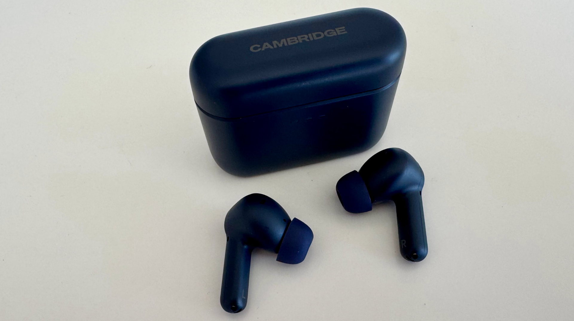 Cambridge Audio earbuds and case in black, on white table