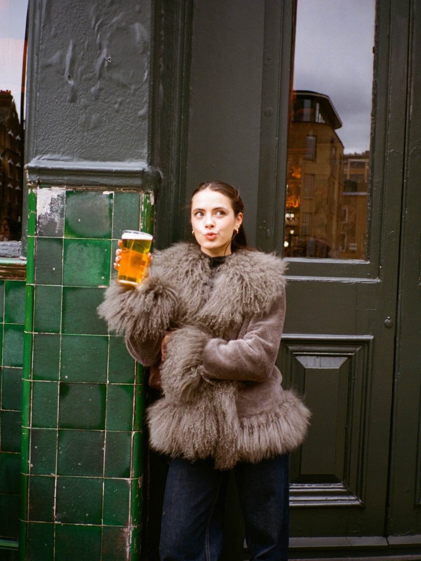 Fashion person Tia Dewitt outside the pub drinking a pint of beer.