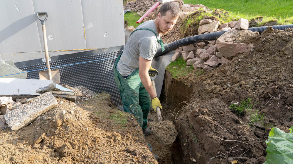 Man digs a drain in the garden