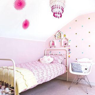 children's bedroom with white wall and cushions on bed