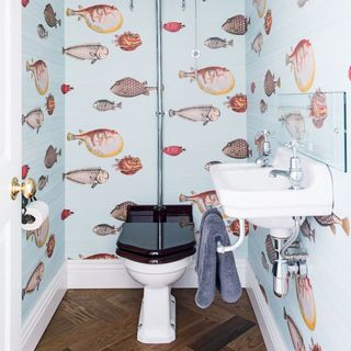 bathroom with blue fish wallpaper and wooden flooring