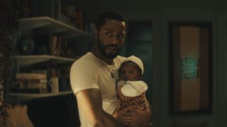 Apollo Kagwa (LaKeith Stanfield) holds a baby in The Changeling