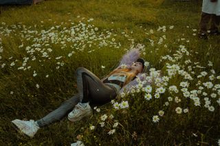 Woman in a catsuit lying in daisies