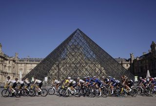 Peloton rides in front of the pyramid at the Louvre
