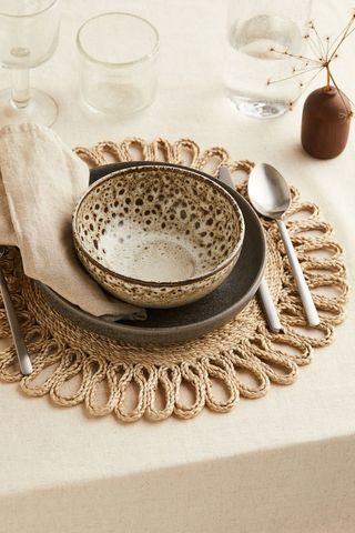 woven jute placemat in an intricate pattern under a set of plates