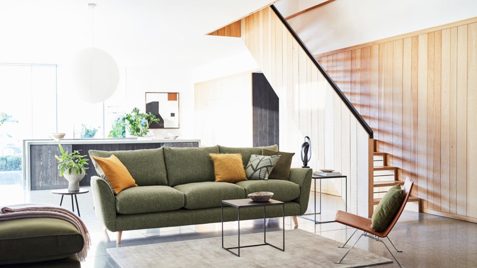 Sage green sofa with yellow cushions in an elegant living room