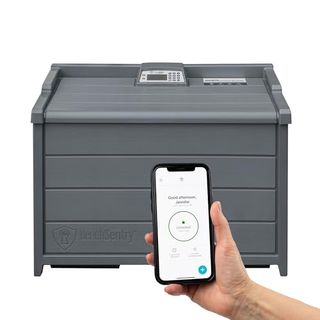 Slate gray delivery box with control panel on top and a hand holding an iphone with app open on white background