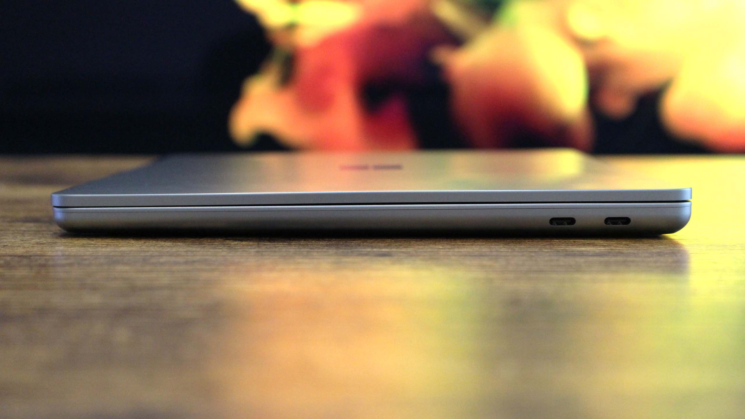 Surface Laptop 13-inch's slim side profile on a wooden table.