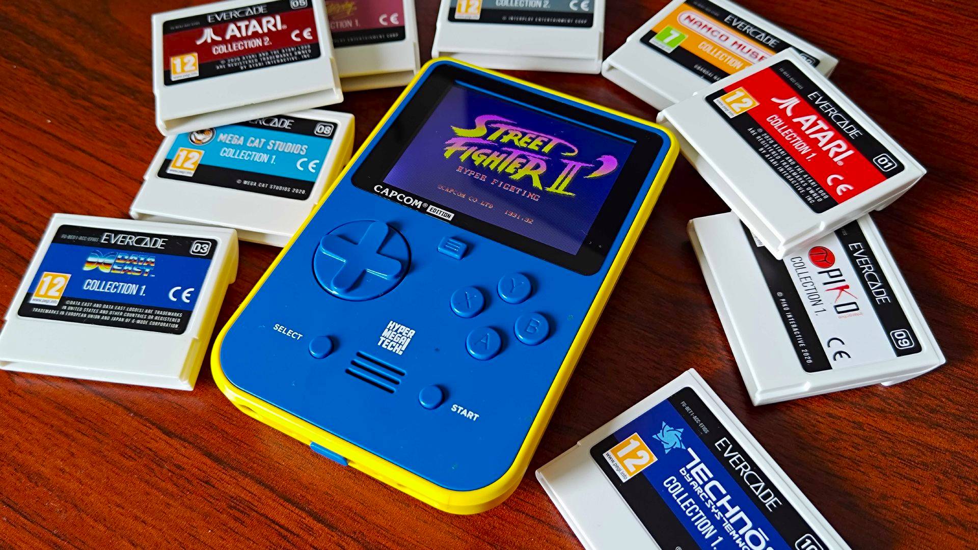 Super Pocket Capcom Edition surrounded by Evercade cartridges on woodgrain desk.