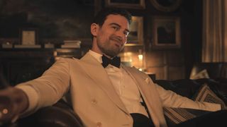 Theo James smiling in a white tux in the Gentlemen Season 2 trailer.