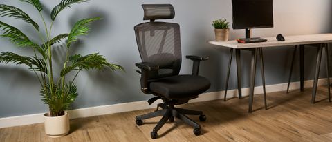 A photo of the Autonomous ErgoChair Pro against a blue-gray wall in an office.