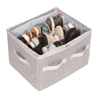 Grau shoe storage box holding multiple pairs of shoes against white background