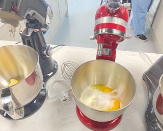 KitchenAid and Cuisinart stand mixers side-by-side, making cake