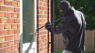 Burglar che irrompe in una casa