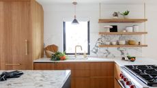 Modern white kitchen with wooden accents and open plan shelving in place of upper cabinets in place of upper kitchen cabinets and wooden lower cabinet fronts