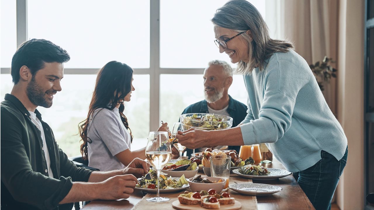 A family dinner includes the parents and an adult son and an adult daughter.