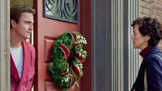 Evan Roderick, Katie Findlay talk in a doorway with a wreath in Sealed with a List