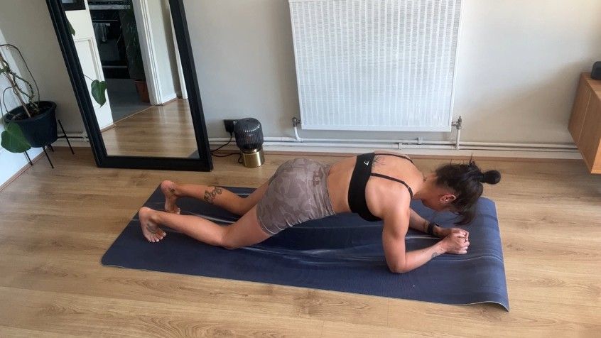 Writer Sam performing forearm kneeling plank on exercise mat during home workout