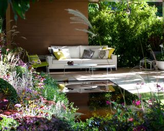 soft layers of perennials around a covered patio area with water feature
