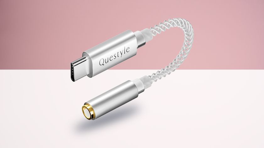The Questyle Qlink-C on a white surface, with a pink background