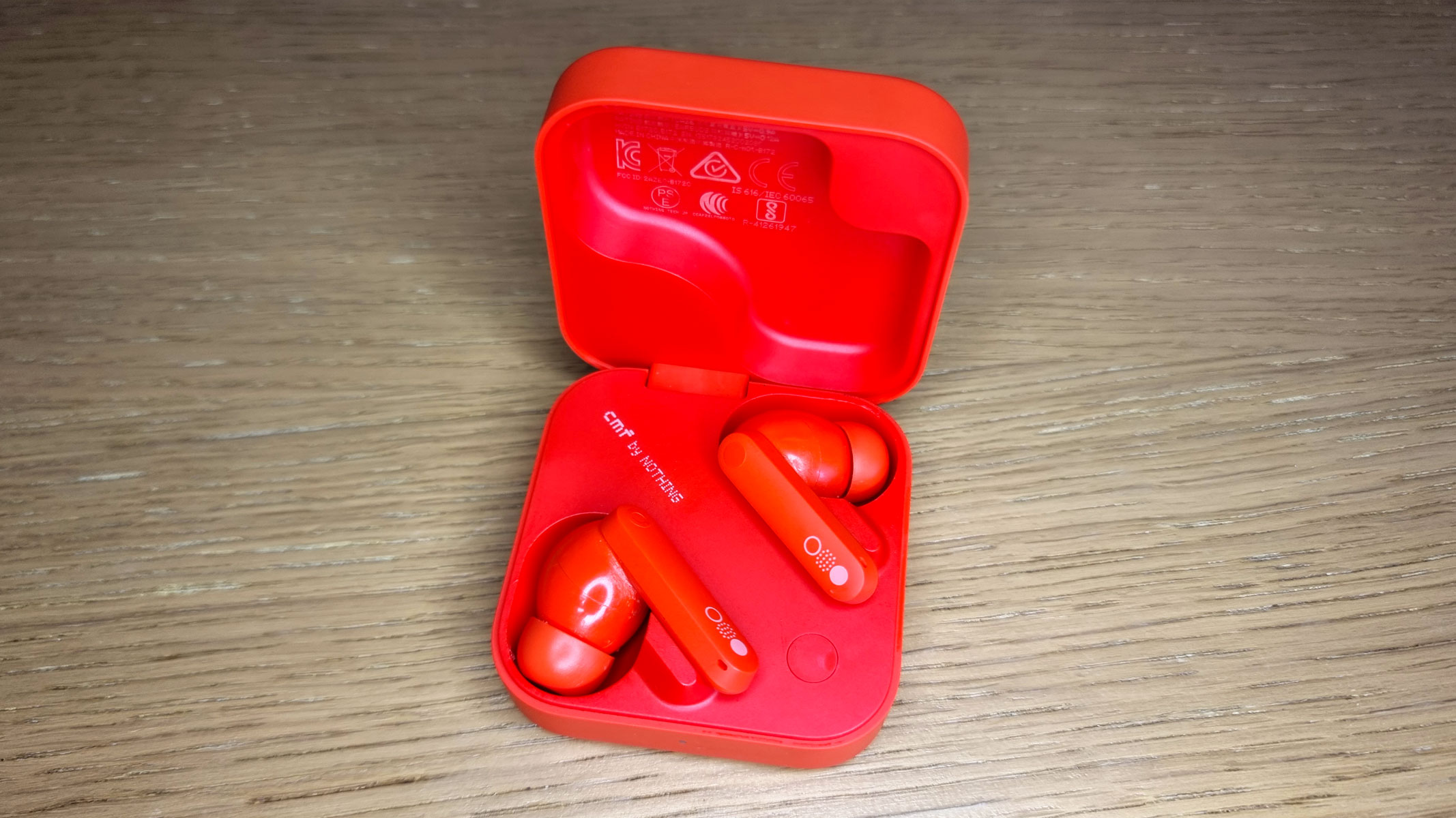 A close-up picture of the CMF by Nothing Buds Pro 2 earbuds in an open charging case
