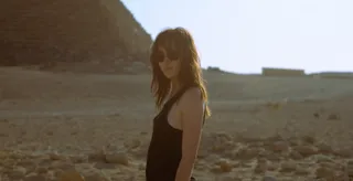 phoebe dynevor wears a black tank top and sunglasses in a desert in the movie inheritance