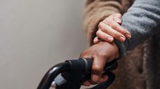 Close up of senior woman helping her husband to walk with his walker