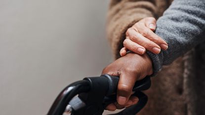 Close up of senior woman helping her husband to walk with his walker