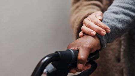 Close up of senior woman helping her husband to walk with his walker