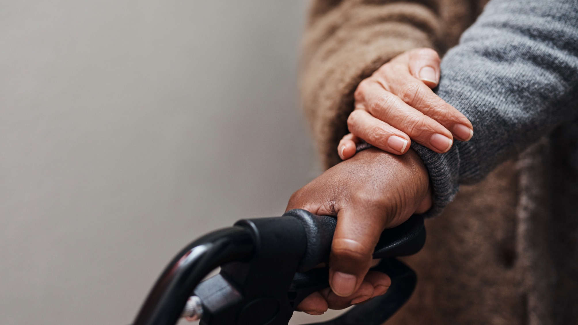 Close up of senior woman helping her husband to walk with his walker