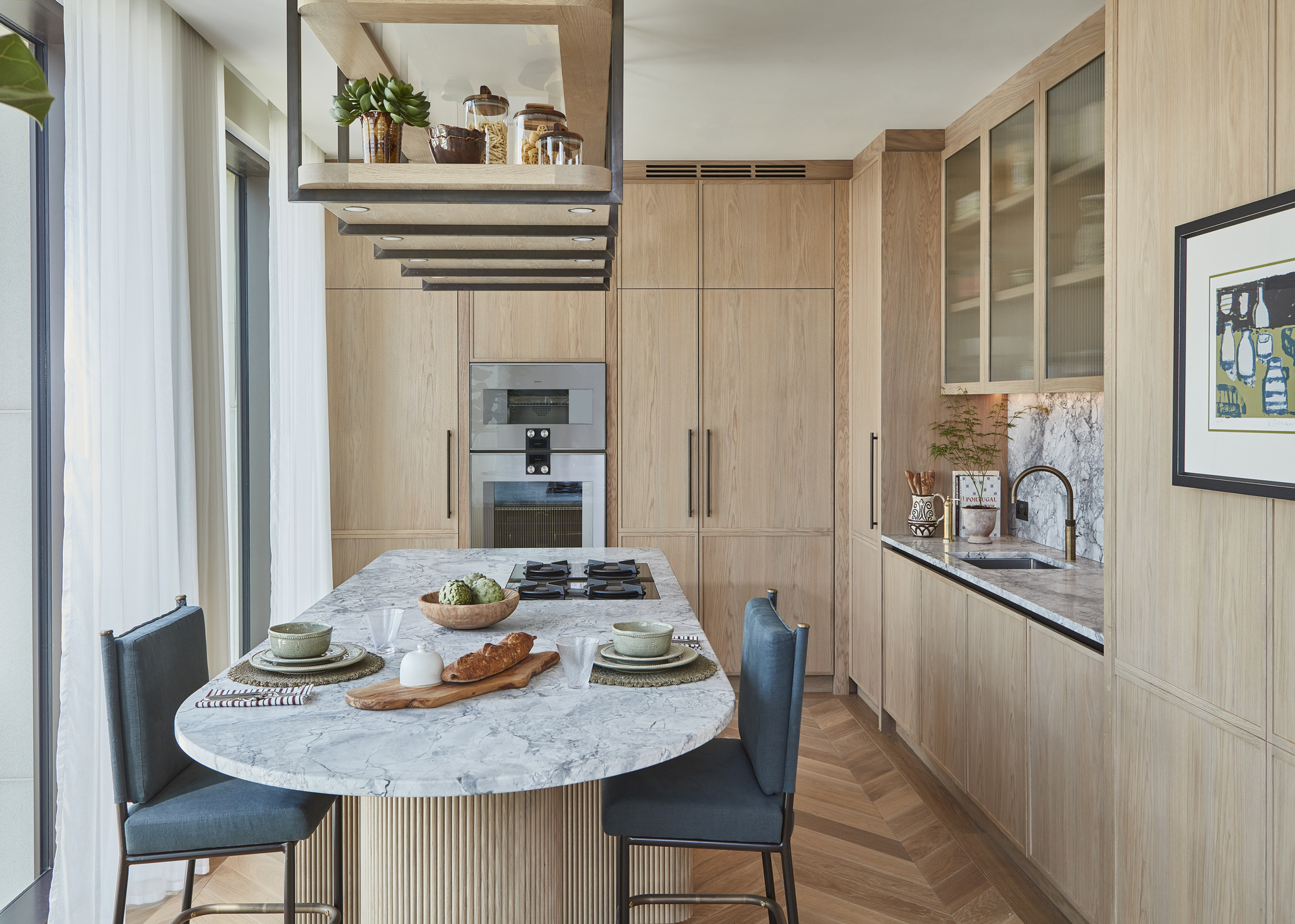 A small kitchen with wooden floor-to-ceiling cabinetry and a marble dining table