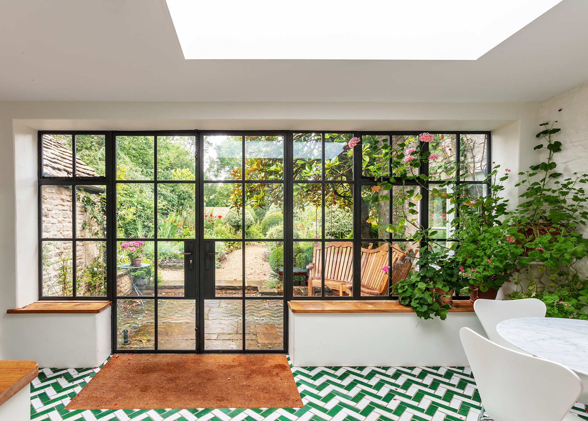 large crittal style glazed wall and patio doors offering light to the garden