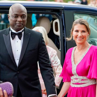 Shaman Durek wears a tuxedo as he holds hands with wife Princess Martha Louise of Norway, who wears a cerise pink gown